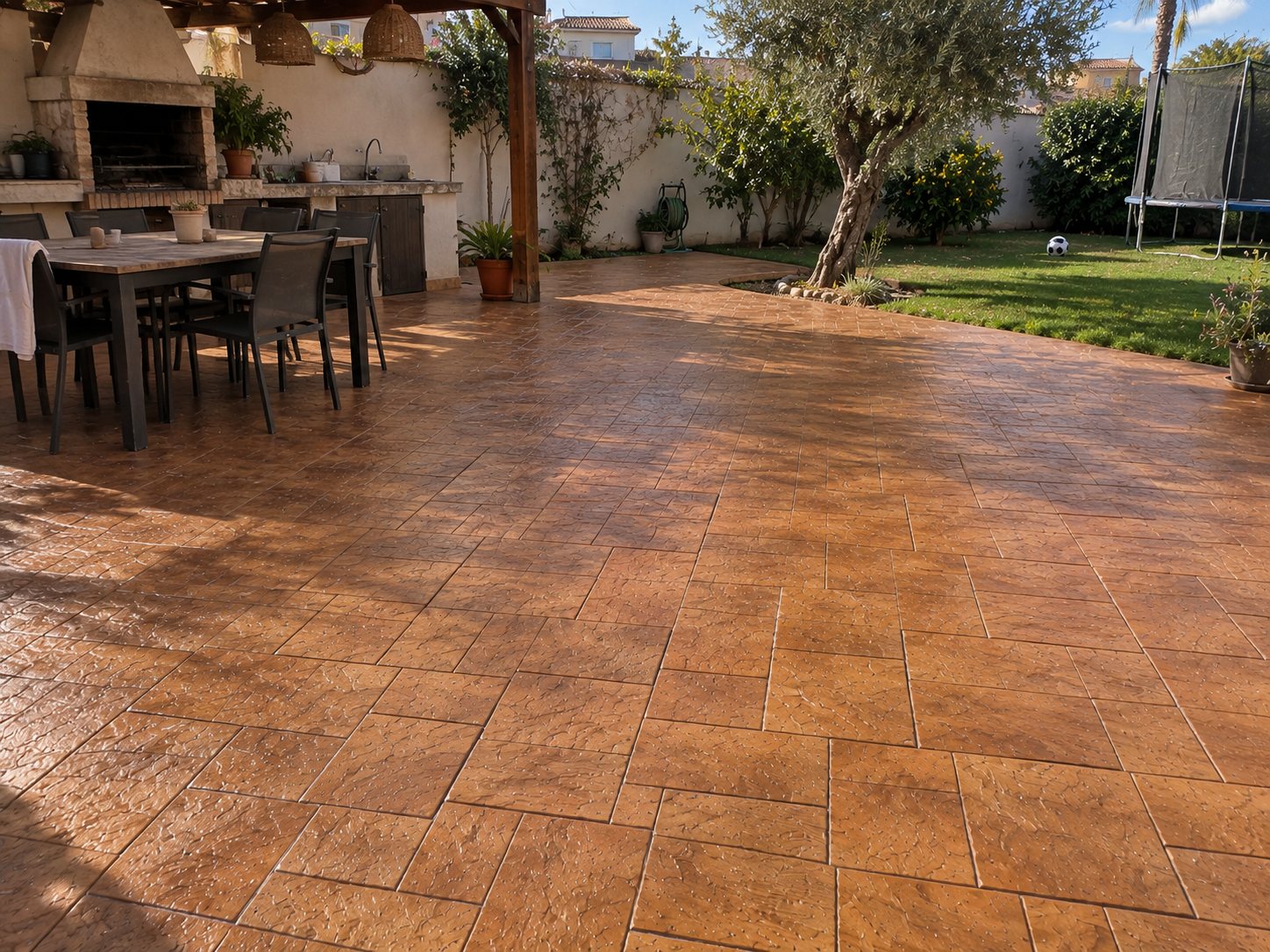 Patio con jardín acabado en hormigón impreso terracota por Hormiklass