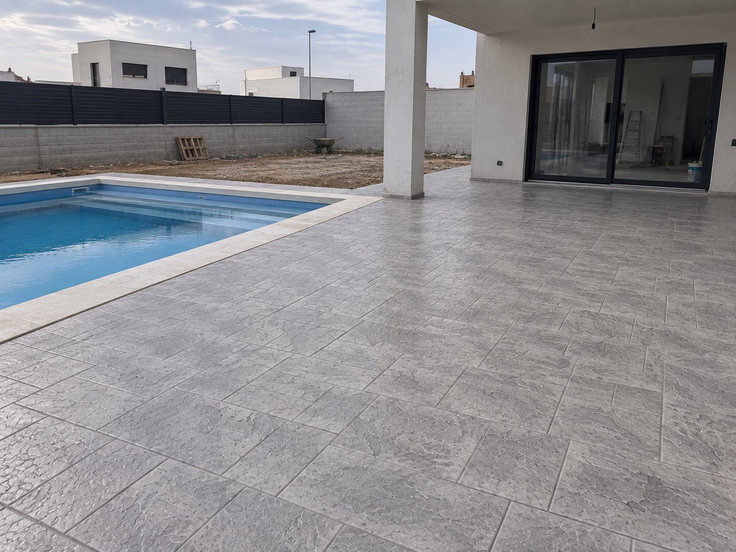 Zona de piscina con pavimento de hormigón impreso gris por Hormiklass