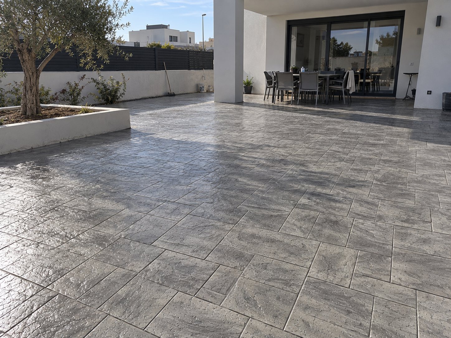 Terraza de vivienda terminada en hormigón impreso gris por Hormiklass