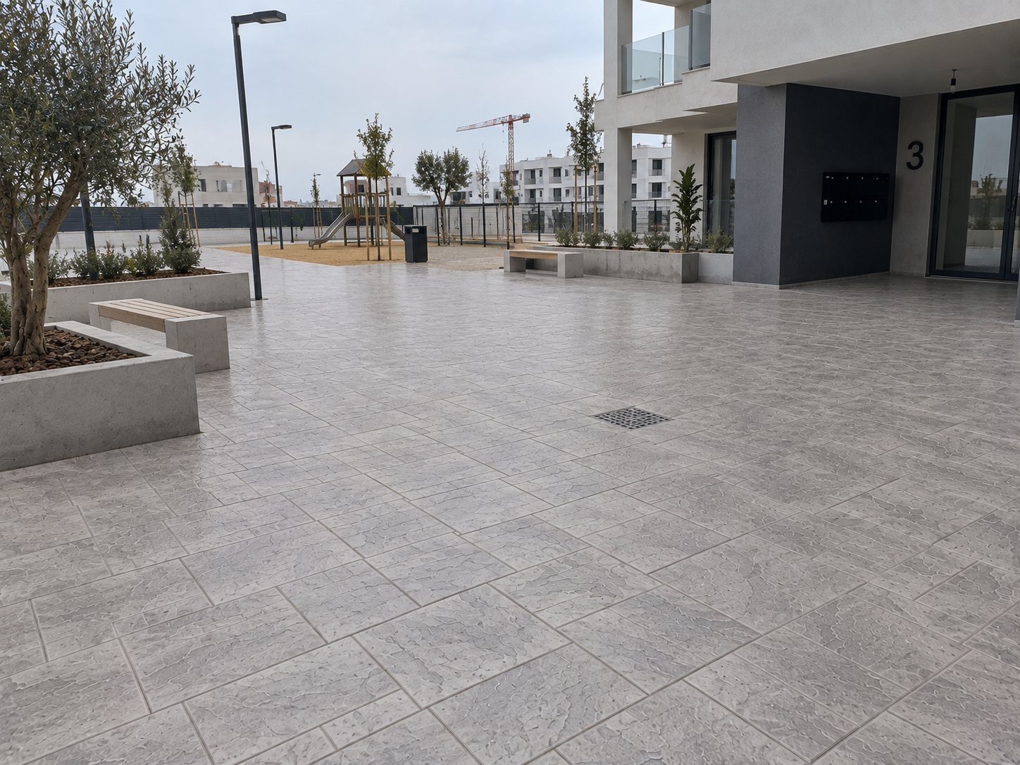 Zona común residencial pavimentada con hormigón impreso gris por Hormiklass